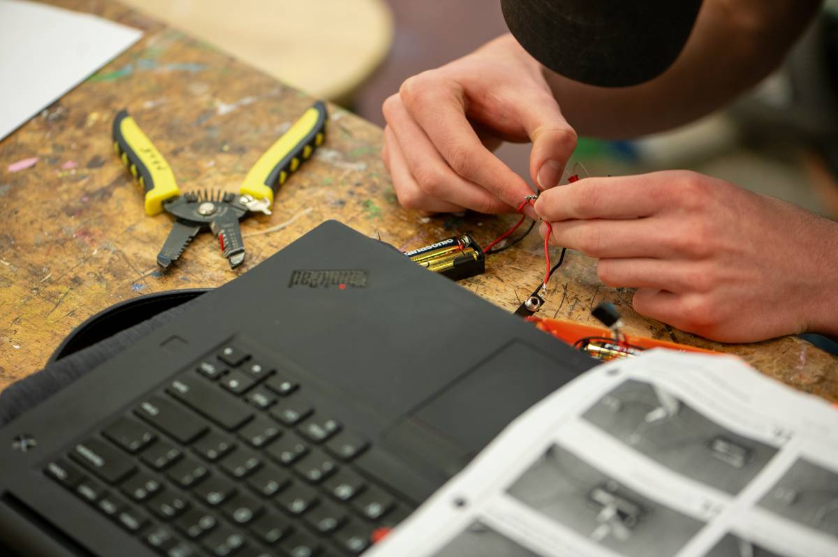 Close-up of hands using an electrical tool soldering iron how to create a clean joint on copper wires